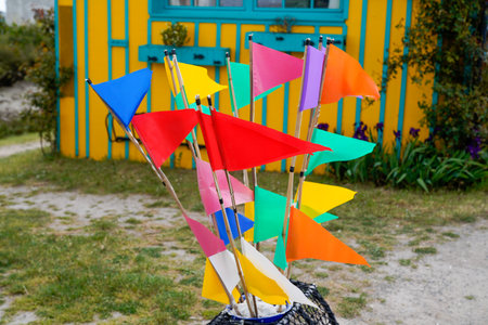 colorful flag on the street vibrant color harbor festival flags fluttering front hut wooden cabin in...