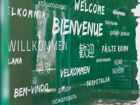 welcome text in multiple languages of various countries in a wall greenの写真素材