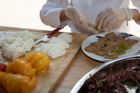 chef preparing caprese style appetizer with fresh mozzarella and heirloom tomatoes in party day