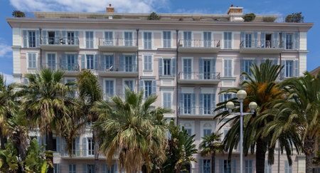 mediterranean apartment building with palm trees and balconiesの写真素材