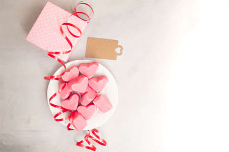 Happy Valentines Day. Gift box with pink chocolate hearts, greeting card and ribbon. With space for textの写真素材