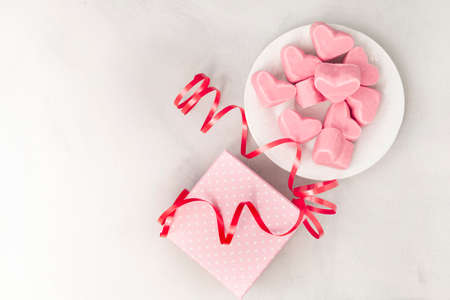 Happy Valentines Day. Gift box with pink chocolate hearts, greeting card and ribbon. With space for...