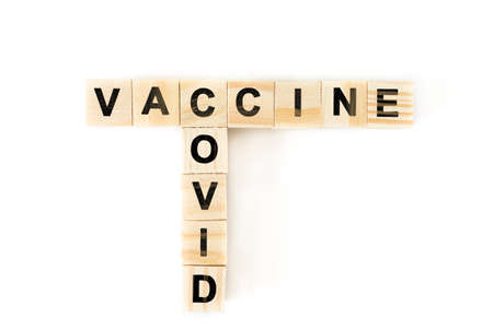 Covid-19 vaccine. Crossword with vaccine and covid. Letters on wooden blocksの写真素材