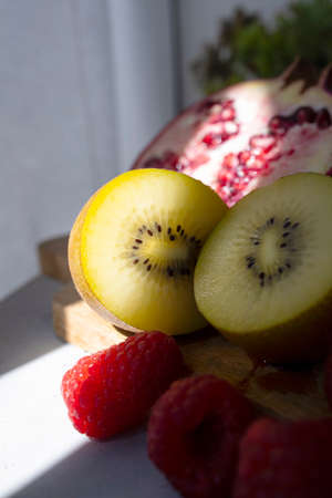 Kiwi, raspberries and pomegranate. Fruits source of vitamin C. Perfect snack or snack for any time. Fruit photography with bright colorsの写真素材
