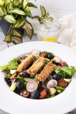 Green leafy salad, tomato, avocado, radishes, olives and tofu fingers. Vegetarian salad. Vegan food photographyの写真素材