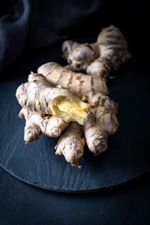 Fresh ginger roots on a dark background
