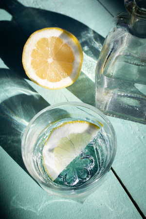 Water with lemon on a turquoise wooden background. Drink with vitamin C. Detox drink