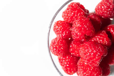 Fresh and ripe raspberries on a white background with copy spaceの写真素材