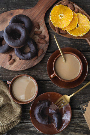 Delicious homemade gluten-free dark chocolate donuts. Sweet breakfast with homemade donuts, coffee with almond milk and fresh fruitの写真素材