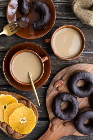 Delicious homemade gluten-free dark chocolate donuts. Sweet breakfast with homemade donuts, coffee with almond milk and fresh fruitの写真素材