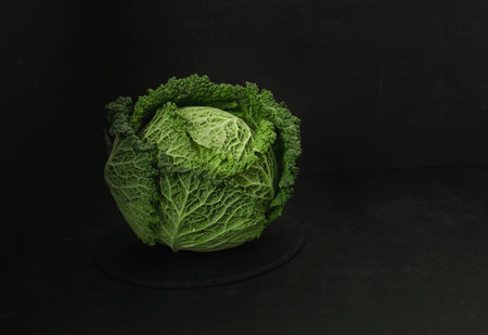 Fresh and raw cabbage on a dark background. Still life with vegetables.の写真素材