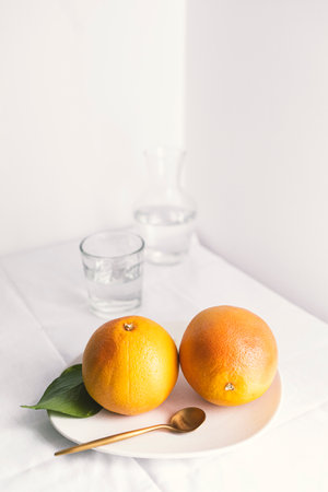 Ripe juicy grapefruits on a white plate on a white backgroundの写真素材