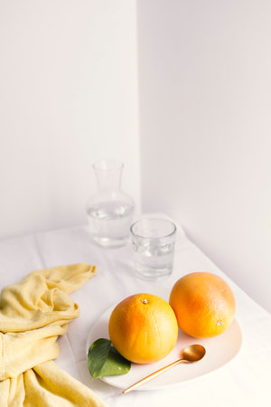 Grapefruits on a white table with a yellow napkinの写真素材
