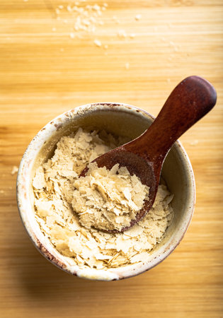 Close-up of a bowl and a wooden spoon with nutritional yeast, excellent vegan proteinの写真素材