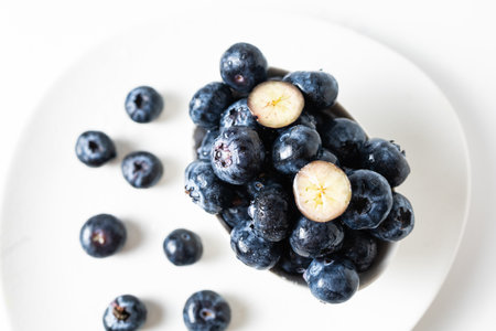 Fresh blueberries in a white bowl on a white background, with room for textの写真素材