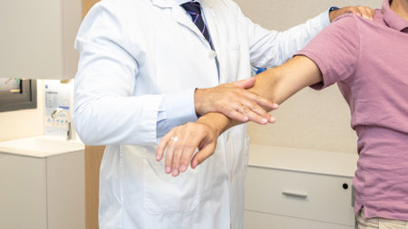 A traumatologist conducting an arm movement test on a patient in a medical consultation.の写真素材