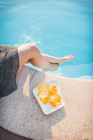 Enjoying a refreshing glass of lemon ginger kombucha with nachos by the pool on a sunny day