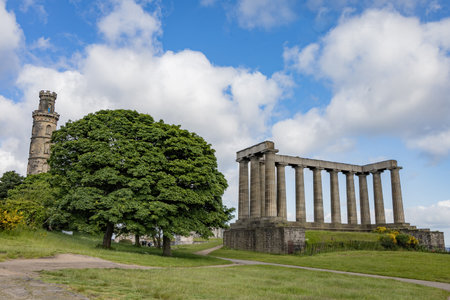 A scenic view of the National Monument of Scotland alongside the Nelson Monument on Calton Hill, Edinburgh, showcasing two iconic landmarksの写真素材