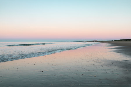 Playa de los Enebrales, Huelva, captured at sunrise with stunning pink skies and turquoise waters, creating a dreamy coastal sceneの写真素材