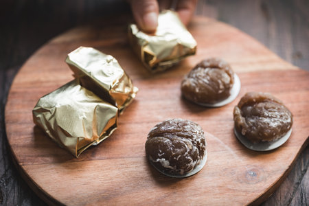 A close-up of traditional marron glacÃ© on a wooden surface, showing the glossy texture and rich color of this beloved seasonal confectionの写真素材