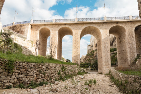A historic stone bridge crossing over Lama Monachile beach in Polignano a Mare, southern Italy.の写真素材