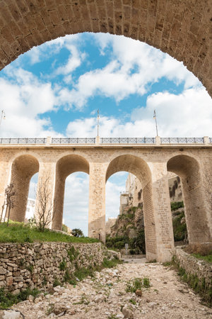 A historic stone bridge crossing over Lama Monachile beach in Polignano a Mare, southern Italy.の写真素材