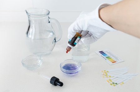 pH analysis of drinking water using a liquid indicator to reveal its acidity or alkalinity, highlighting the importance of water quality in daily health and hydration.の写真素材