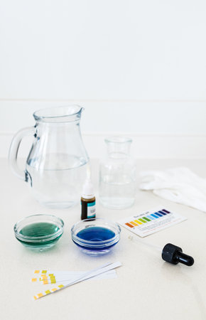 Photographs of a water pH testing kit including color indicator drops and a comparison chart, used to analyze the acidity or alkalinity of drinking water in home or educational settings.の写真素材