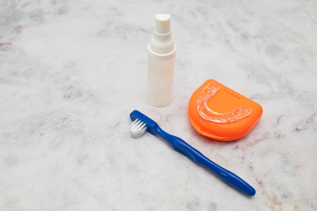 A clear dental mouth guard designed to prevent teeth grinding (bruxism), shown in close-up on a clean, white background. Ideal for content related to oral health, dental care, and sleep wellness.の写真素材