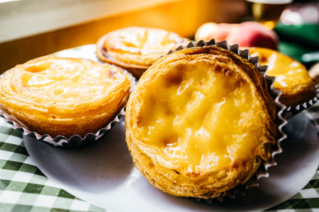 Delicious close-up of traditional Portuguese egg tarts with crispy layers and creamy center
