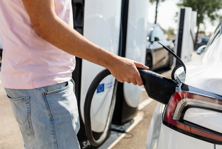 Modern electric vehicle connected to a charging station, concept of clean energy, sustainability,...
