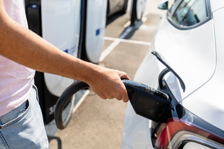 Modern electric vehicle connected to a charging station, concept of clean energy, sustainability,...