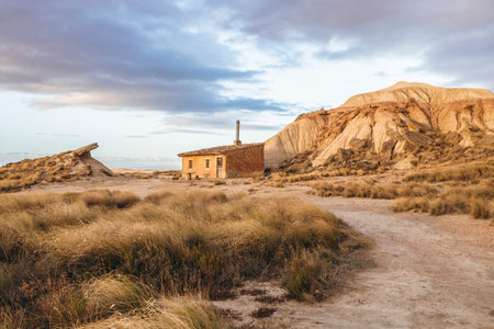 Beautiful sunrise over the semi-desert landscape of Bardenas Reales Natural Park in Navarra, Spain. Golden light illuminating the arid hills and eroded formations.の写真素材