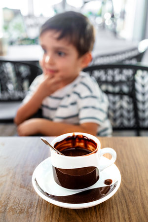 Adorable child enjoying a warm cup of hot chocolateの写真素材
