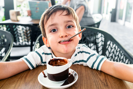 Adorable child enjoying a warm cup of hot chocolateの写真素材