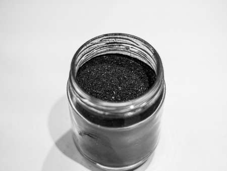 Activated charcoal powder for cosmetic face masks in a jar top view with copy spaceの写真素材