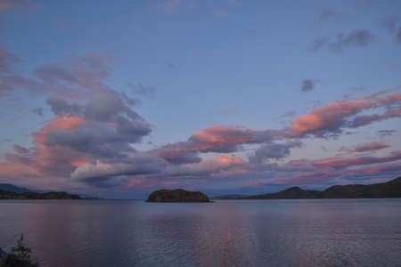evening bright pink red sunset with clouds on lake baikal with islands and mountains