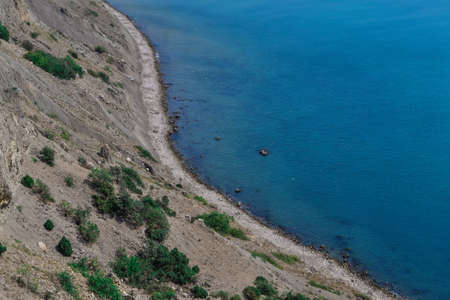 view of beautiful stones coast with green trees of bay of sea with blue water. Crimea, Russia, summer sunny landscapeの写真素材