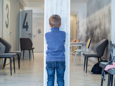 Children play hide and seek. The child is standing by a post in the room. Happy childhood and games in itの写真素材