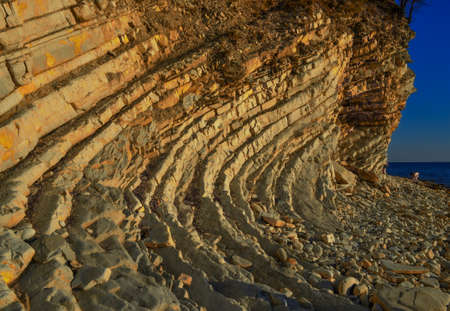 Layered sandy light twisted cliffs made of stone bricks on Black Sea coast, in Blue Bay (Golubaya...