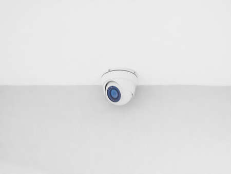 Round spherical white chamber surveillance hanging from the ceiling. Light interior, wall