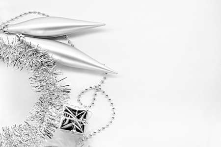 Silver long toys, little gift, shiny tinsel. New year decorations on a white background. Christmas concept. Template for textの写真素材