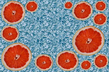 cut bright red orange halves grapefruit slices, circles of different sizes on water pattern...
