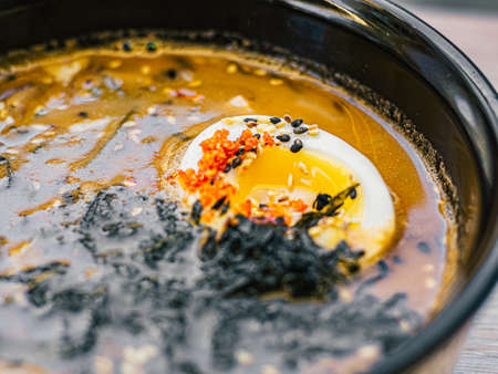 Cut egg, sesame seeds, nori in Hot miso soup in black and white plate on table. Top view. Dish of Japanese cuisine in Asian restaurant, cafe. Close upの写真素材