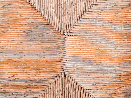 Geometric pattern of seat of a wicker chair. Furniture in a cafe. Beige color