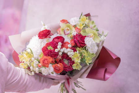 A lush beautiful bouquet of red, orange, yellow, white cute delicate flowers of different sizes and...