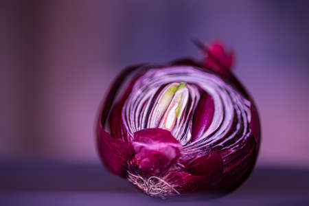 Cut the red sprouted and puff onions in half on a black plate. Side view. Place for your text. Conceptual macro photography with pink.の写真素材