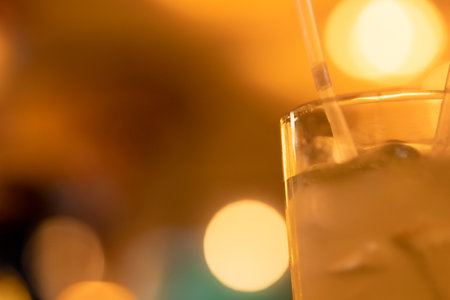 Glass with lemonade, lemon wedges, ice cubes, straws. Summer cold refreshing alcoholic cocktail, drink. Macro, close-up. Place for textの写真素材