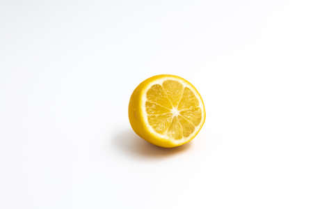 One cut citrus fruit a hybrid of orange and lemon yellow color on a white backgroundの写真素材