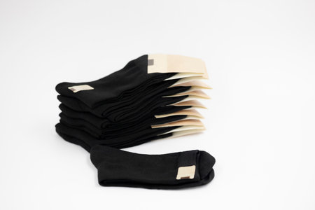 stack of new black socks with blank labels on white background, close-upの写真素材